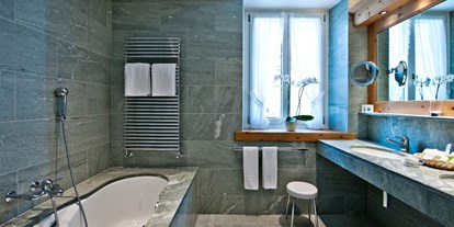 Wanderurlaub - Schuhputzmöglichkeit - Zuoz - Badezimmer mit einheimischen Verde Spluga Granit und Marmor - Parkhotel Margna