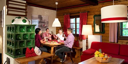 Wanderurlaub - Unterkunftsart: Aparthotel - Kremsbrücke - Wohnraum Ausstattung Gipfel mit Essecke und Kachelofen  - Slow Travel Resort Kirchleitn