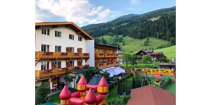 Wanderurlaub - Wandern mit Kinderwagen - PLZ 5562 (Österreich) - HAusansicht Garten mit Spielplatz - Familienhotel Botenwirt ***S