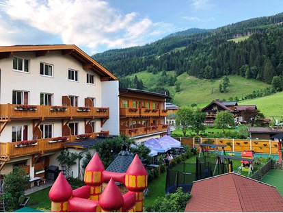 Wanderurlaub - Obertauern - HAusansicht Garten mit Spielplatz - Familienhotel Botenwirt ***S