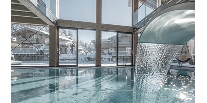 Wanderurlaub - Hotelbar - Oberösterreich - INNs HOLZ Ausblick vom Indoorpool auf das Chaletdorf im Winter - INNs HOLZ Chaletdorf