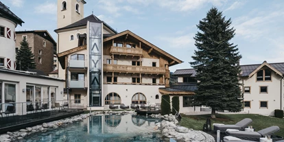 Wanderurlaub - Hotel-Schwerpunkt: Wandern & Kulinarik - Aurach bei Kitzbühel - VAYA Post Saalbach Außenansicht mit Pool - VAYA Post Saalbach