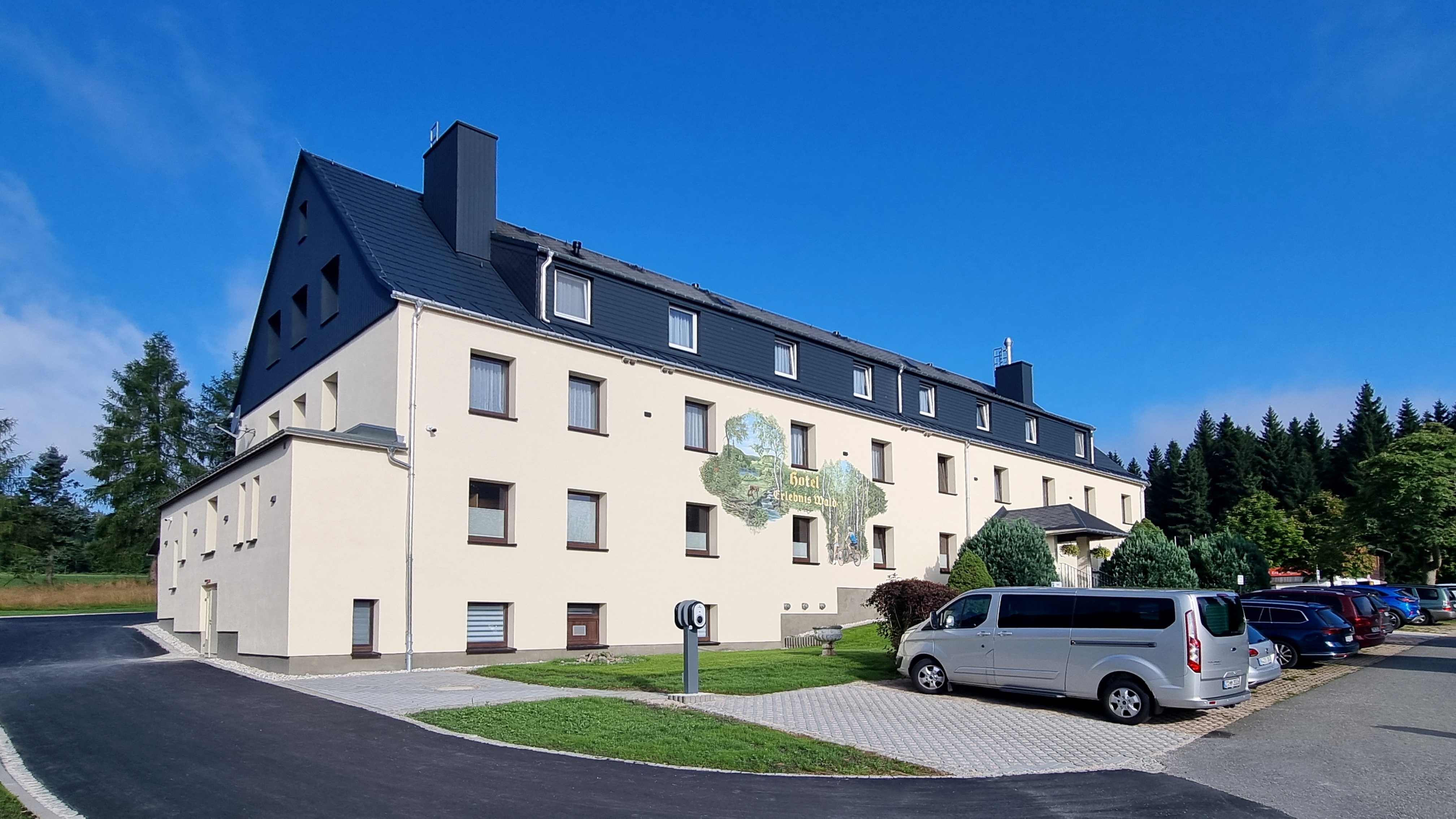 Wanderurlaub: Unser Hotel, von der Ostseite, mit Parkmöglichkeit direkt vor dem Hotel, Ladestation für Elelktroautos und Fahrräder. - Hotel Erlebnis Wald Johanngeorgenstadt