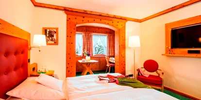Wanderurlaub - Hotel-Schwerpunkt: Wandern & Biken - Krün - Das Doppelzimmer Dorfblick, in Zirbenholz ausgestattet hat ein kleines Stüberl mit 2-Sitzer und Schreibtisch. - Parkhotel Wallgau