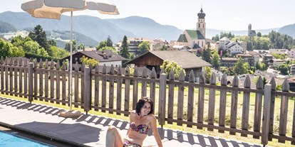 Wanderurlaub - Touren: Mehrtagestour - Trentino-Südtirol - Schwimmbad und Blick auf Völs am Schlern. -  Hotel Emmy-five elements