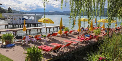 Wanderurlaub - Verpflegung: Halbpension - Rosenegg (Ebenthal in Kärnten) - Urlaub im Flairhotel am Wörthersee- der hauseigene Strand hat auch eine tolle Liegewiese und einen Steg zum geniessen - Flairhotel am Wörthersee
