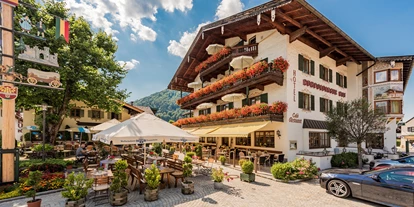 Wanderurlaub - Fahrstuhl - Bayern - Hotelansicht mit Dorfbrunnen und Maibaum - Hotel Ruhpoldinger Hof