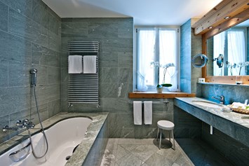 Wanderhotel: Badezimmer mit einheimischen Verde Spluga Granit und Marmor - Parkhotel Margna