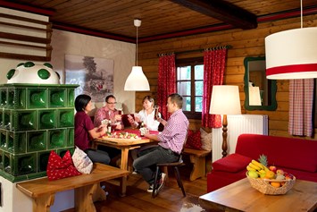 Wanderhotel: Wohnraum Ausstattung Gipfel mit Essecke und Kachelofen  - Slow Travel Resort Kirchleitn