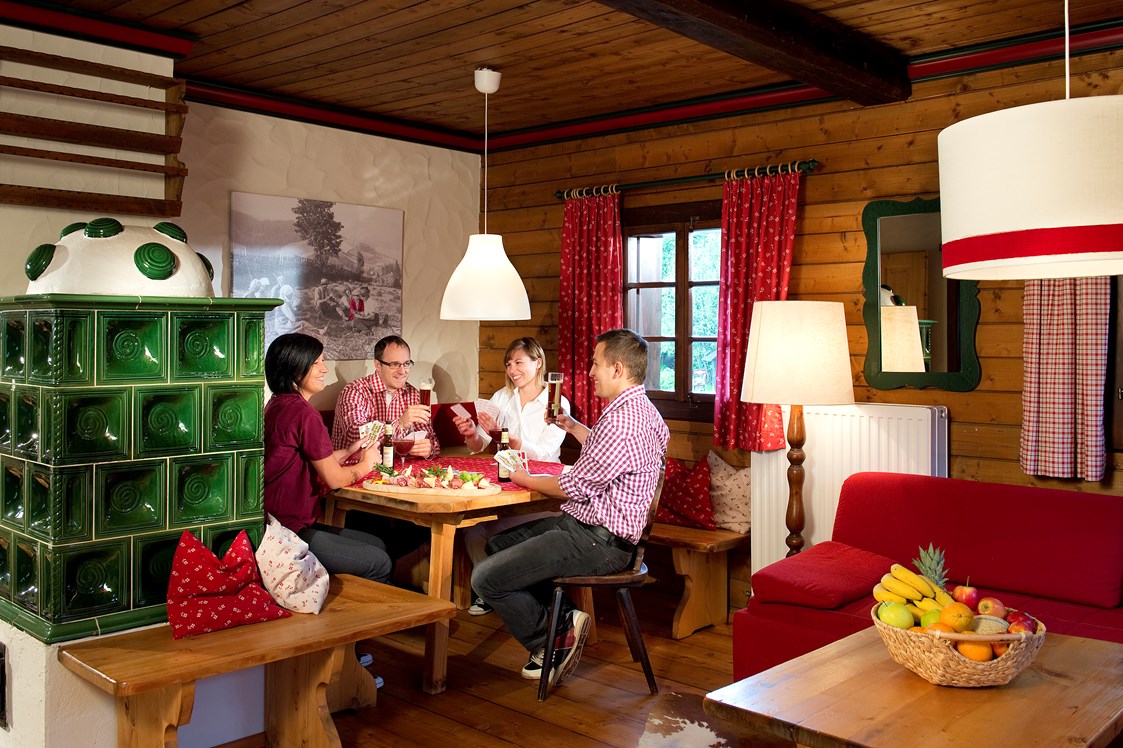 Wanderhotel: Wohnraum Ausstattung Gipfel mit Essecke und Kachelofen  - Slow Travel Resort Kirchleitn