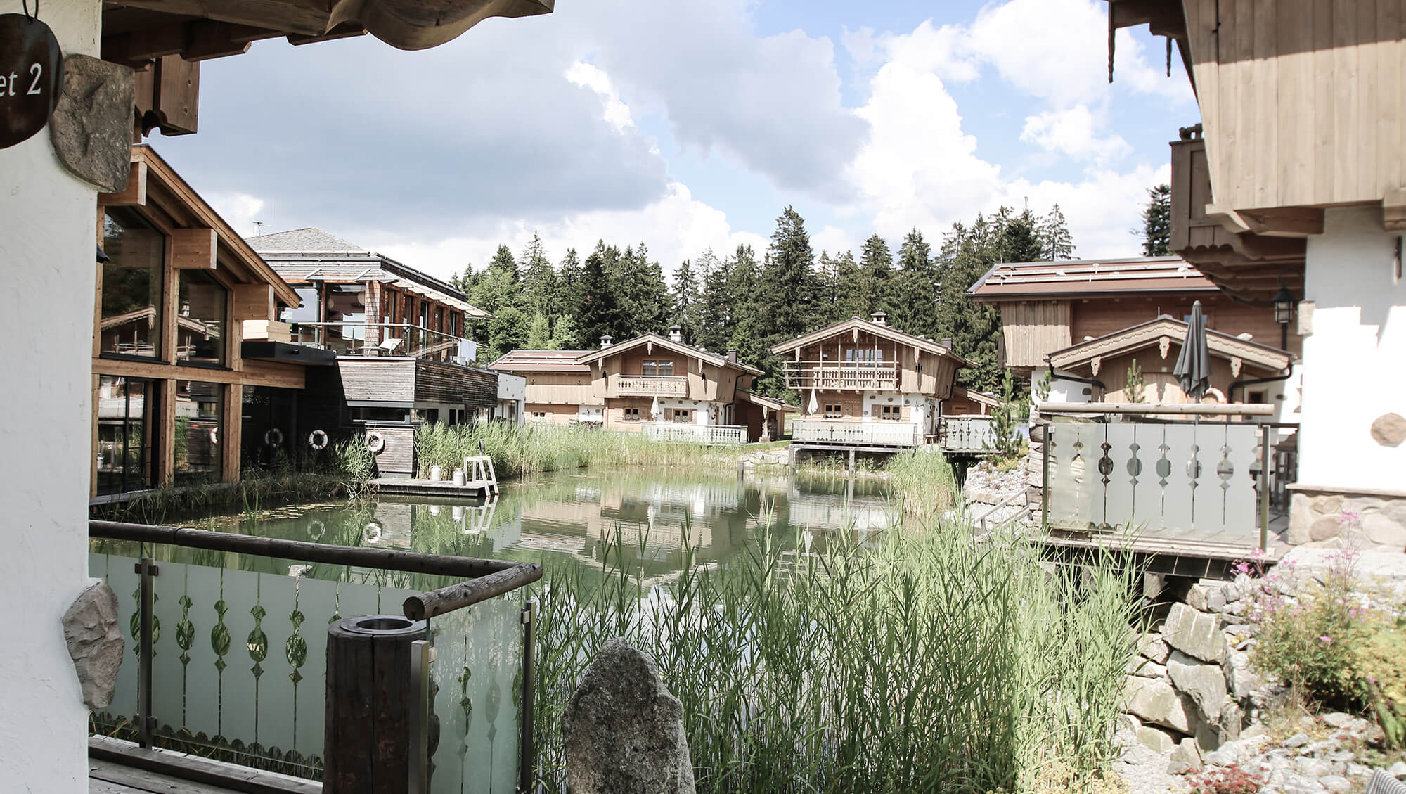 Wanderhotel: INNs HOLZ Chaletdorf mit INNs HOLZ See im Sommer - INNs HOLZ Chaletdorf