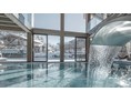 Wanderhotel: INNs HOLZ Ausblick vom Indoorpool auf das Chaletdorf im Winter - INNs HOLZ Chaletdorf