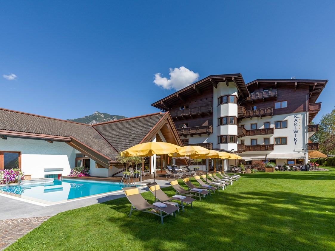 Wanderhotel: Aussenbereich mit Pool und Liegewiese - Hotel Karlwirt - Alpine Wellness am Achensee