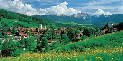 Wanderurlaub - Allgäu - Blick über Oberstaufen mit der Pfarrkirche St. Peter und Paul und der Nagelfluhkette im Hintergrund. - Vitalhotel Interest